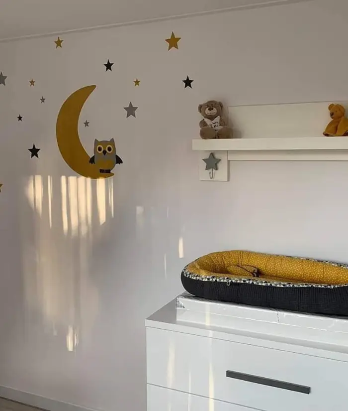 Okergele babykamer met een uil op de maan muurdecoratie